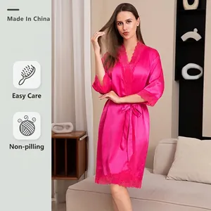 Lussuosa vestaglia in raso rosso rosa con scollo a V e pizzo in un ambiente domestico