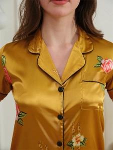 Detail of ice silk pajama top featuring golden floral prints and classic lapel collar