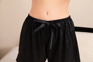 Détails du short de pyjama en satin noir avec motif léopard et nœud décoratif