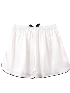Detailed close-up of smooth ice silk sleep shorts with black bow tie and contrast piping