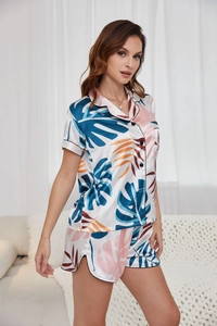 Detail view of ice silk pajama set with tropical leaf print and black piping edges
