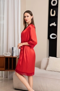 Dettaglio accappatoio in seta rossa con pizzo sulle maniche e una cintura elegante in vita