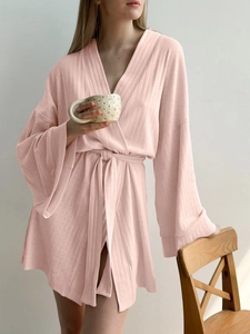 Detail of light pink pointelle knit bathrobe showing the delicate texture and tied waist