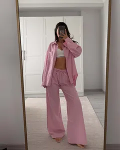 Detail of pink striped loungewear set featuring long sleeve shirt and wide leg trousers