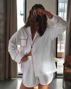 Detail of the white cotton pajama set featuring red piping and button contrast