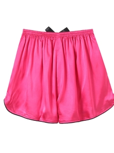 Detail of rose pink ice silk sleep shorts featuring a black bow and contrast hem