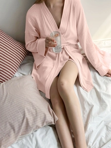Detail shot of pink waffle knit texture and waist tie on a cozy women's bathrobe