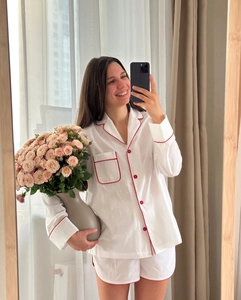 Detail of white cotton pajamas with red contrast piping on lapels and front pocket