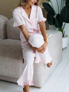 Detail of pink gingham cotton pajamas set with ruffles on short sleeve cuffs and hem
