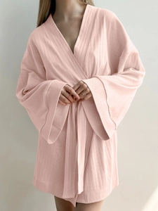 Detail of pink knit robe with vertical textured patterns and adjustable waist tie
