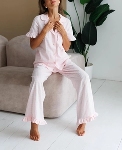 Detailed texture of pink plaid cotton pajamas set with ruffled hem and sleeve cuffs