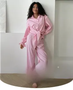 Close-up of pink checkered pajama set with ruffled cuffs and tie-waist polyester fabric