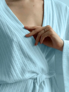 Detailed view of light blue waffle knit texture and waist tie on women's soft bathrobe