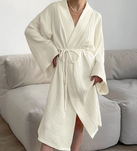 Gros plan sur la texture en mousseline de coton blanc d'un peignoir ample et respirant