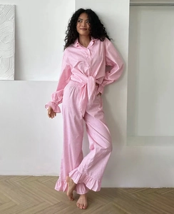 Detail of pink gingham pajama set featuring ruffled edges and waist tie design