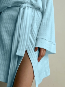 Detail of light blue waffle knit fabric on long-sleeved robe with adjustable tie belt