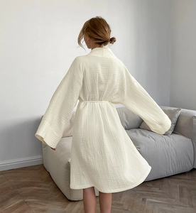 Vue arrière du peignoir en gaze de coton crème avec ceinture dans un intérieur minimaliste
