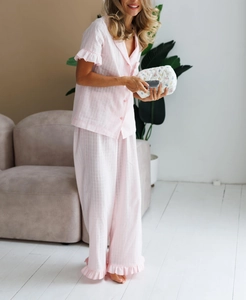 Detail of pink plaid pajamas featuring ruffled short sleeves and lightweight jacquard cotton
