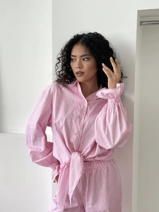 Detail of pink gingham loungewear showing the tie-front waist and ruffled elastic cuffs