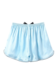 Detail of light blue satin sleep shorts with black bow and silk-like texture fabric
