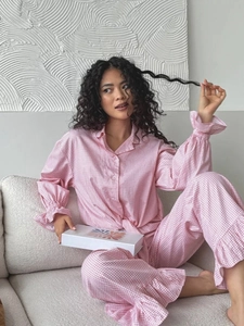 Detail of pink plaid pajama set featuring ruffle trim on cuffs and cozy cotton fabric