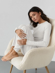 Close-up of white ribbed loungewear set featuring elegant lettuce edge cuffs and hem