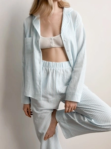 Detail of light blue striped cotton pajama set showing texture of the shirt and pants