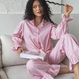 Pink gingham pajama set for women featuring ruffled long sleeves and matching pants