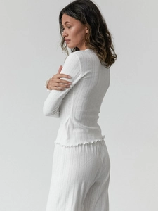 Detail of white heart pointelle knit fabric and lettuce edge hem on pajama set