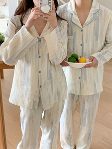 Detail of couple's cotton pajamas featuring blue piped edges and watercolor vertical print