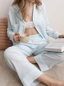 Detail of light blue striped cotton pajamas set with button-down top and comfortable pants