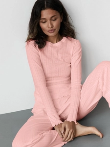 Close-up of pink loungewear detail showing heart jacquard pattern and ribbed fabric texture