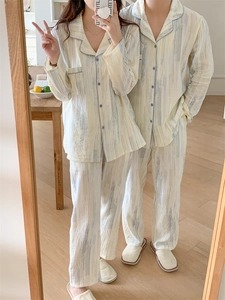 Detail of couple's beige cotton pajamas set with abstract stripes and button-down design