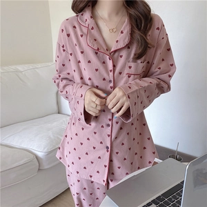 Detail of light pink heart print pajama top with red piping and lapel collar design