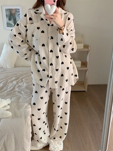 Detail of soft cotton cream pajamas set featuring black heart patterns and button-up lapels