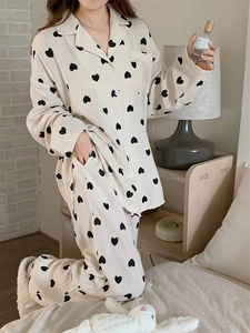 Detail of soft cotton gauze women's pajamas featuring black heart patterns on cream fabric