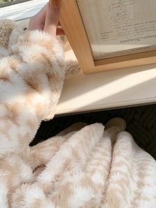 Detailed view of thick houndstooth plush robe with soft warm coral fleece texture