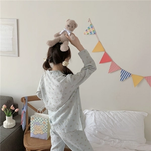 Vue détaillée du pyjama à carreaux bleu clair dans un décor de chambre confortable