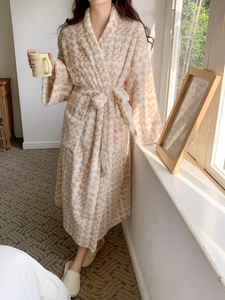 Close-up of thick plush bathrobe featuring a brown houndstooth pattern and a waist tie