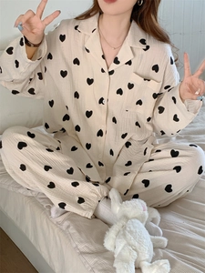Detail of soft cotton gauze pajamas featuring black heart prints and a classic button collar
