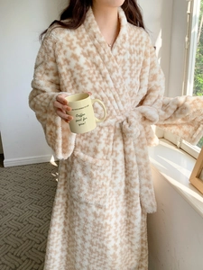 Detail of soft plush flannel fabric and large pocket on a long houndstooth bathrobe