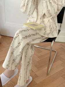 Détail d'un ensemble de détente matelassé à fleurs avec nœud délicat sur la poche
