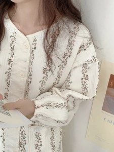 Détail du haut de pyjama à fleurs avec col en dentelle et motif de vigne sur blanc cassé