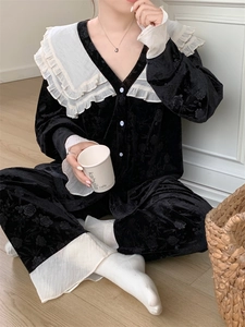 Détail d'un pyjama en velours noir avec textures florales et col volanté contrastant