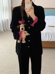 Détail d'un élégant pyjama en velours noir avec bordure en dentelle rose et boutons