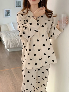 Detail of cotton pajama set with black heart prints on breathable beige fabric