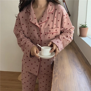 Detail of soft pink long-sleeved pajama set with red heart prints and button-down collar