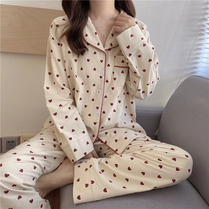 Detail of soft cotton pajama set featuring red heart patterns and classic lapel piping