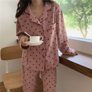 Close-up of pink heart print pajama set featuring a lapel collar and red piped edges