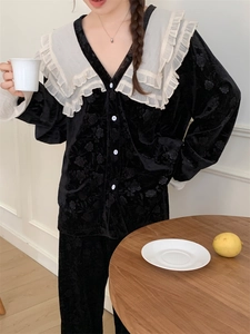 Détail du pyjama en velours noir avec gaufrage de roses et grand col en dentelle blanche